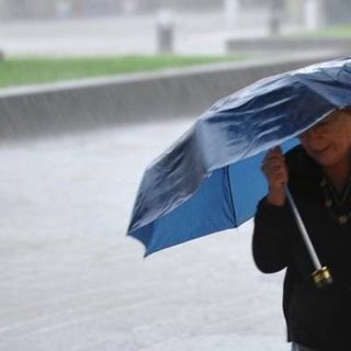 persona che si ripara dalla pioggia con un ombrello