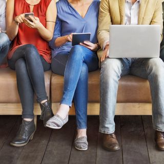 Persone sedute alle prese con dispositivi digitali