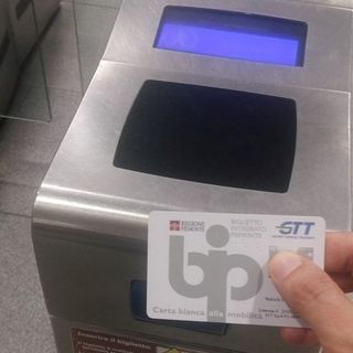 mano mostra abbonamento gtt bip card davanti all'ingresso della metro