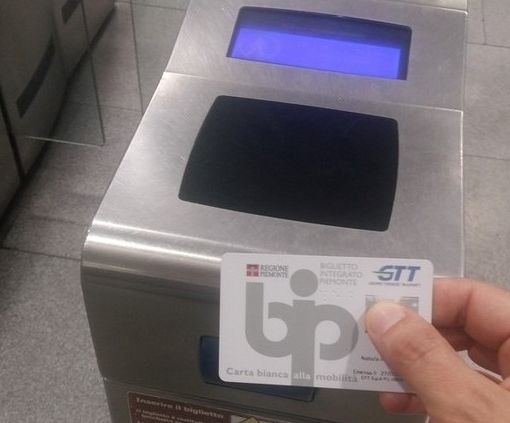 mano mostra abbonamento gtt bip card davanti all'ingresso della metro