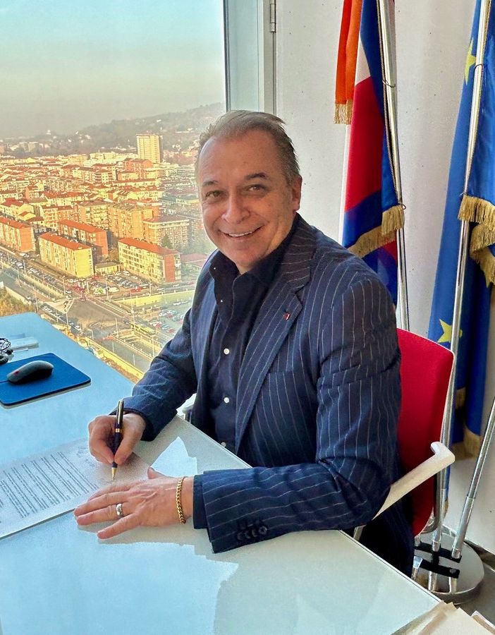 uomo biondo sorridente seduto alla scrivania