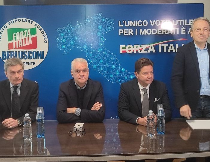 Persone davanti a simboli elettorali