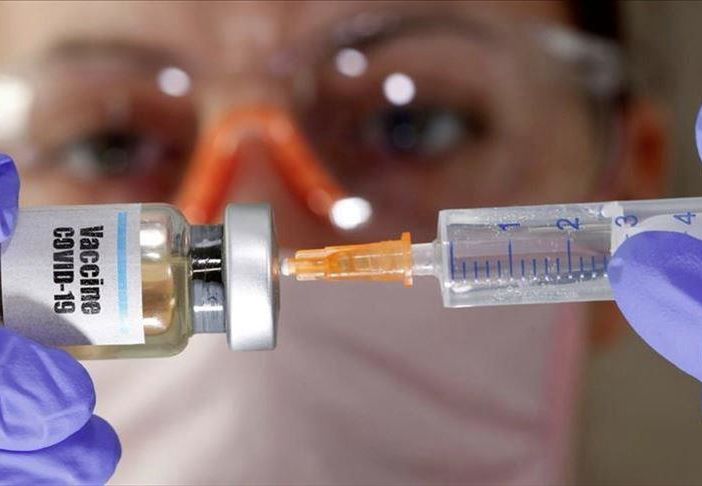 medico con una siringa in cui sta inserendo un vaccino