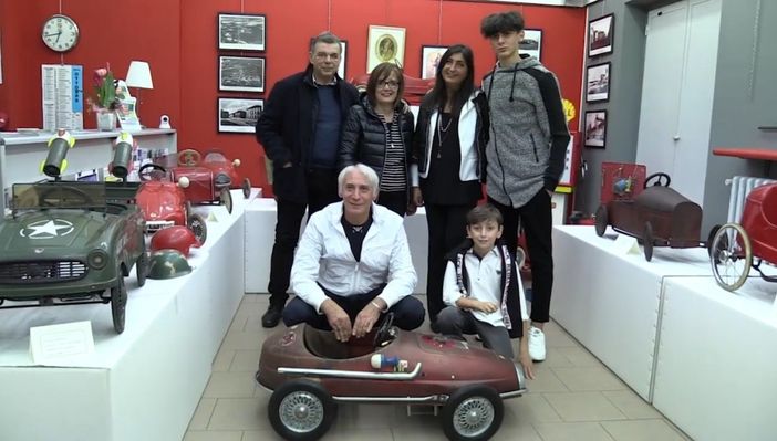 Persone accovacciate vicino a un modellino di auto in scala