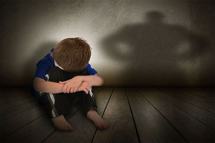 Bambino in difficoltà seduto a terra