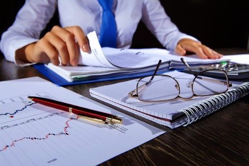 Persona con carte e bilanci davanti a sé Persona con carte e bilanci davanti a sé