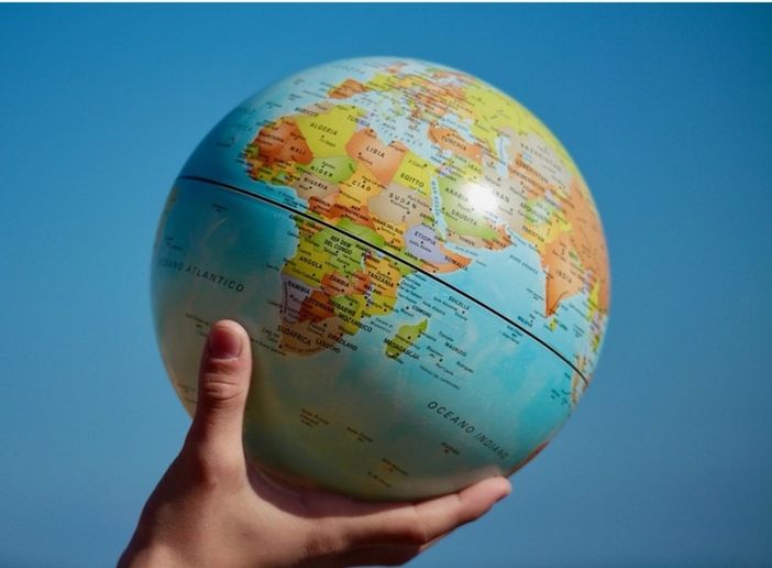 mano che regge un mappamondo mano che regge un mappamondo