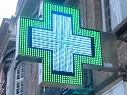 L'insegna luminosa di una farmacia a forma di croce