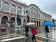 Persone con ombrello davanti a Porta Nuova