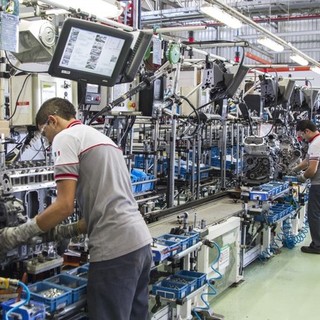 Operai al lavoro in catena di montaggio